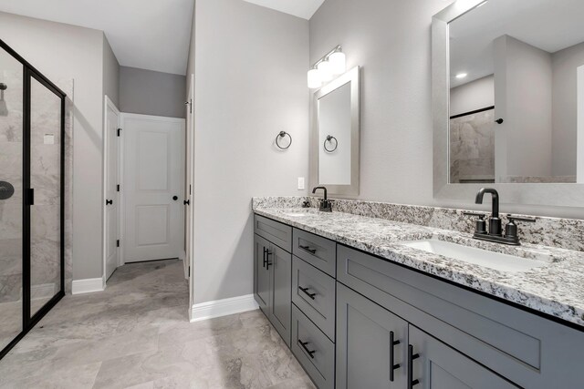 bathroom featuring marble finish floor, a sink, and a shower stall