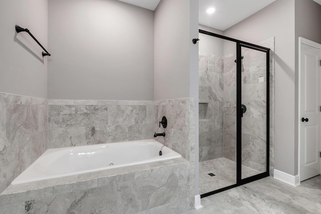 bathroom with a shower stall, a bath, marble finish floor, and baseboards