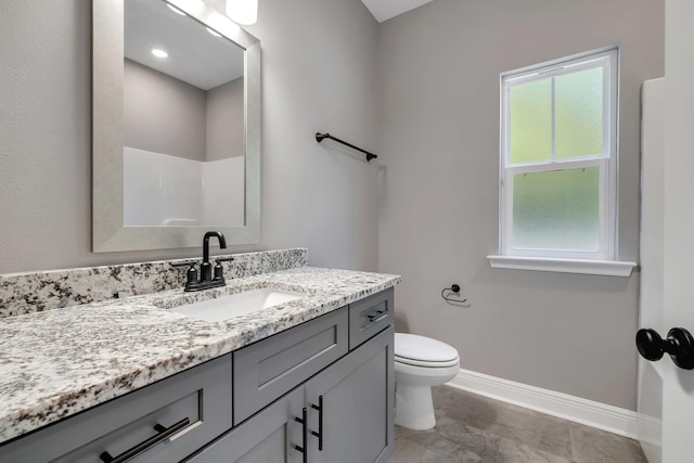 full bathroom featuring baseboards, marble finish floor, toilet, and vanity