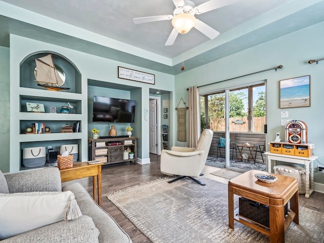 living room featuring ceiling fan, wood-type flooring, and built in features