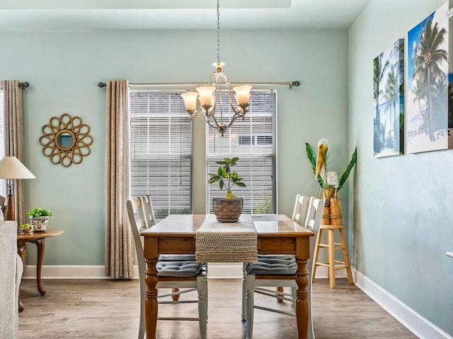 dining area featuring light hardwood / wood-style floors and a chandelier