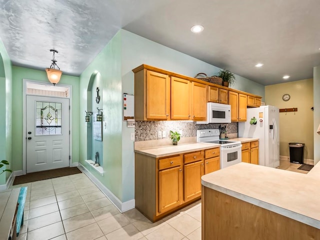 kitchen featuring hanging light fixtures, light tile patterned floors, white appliances, and backsplash