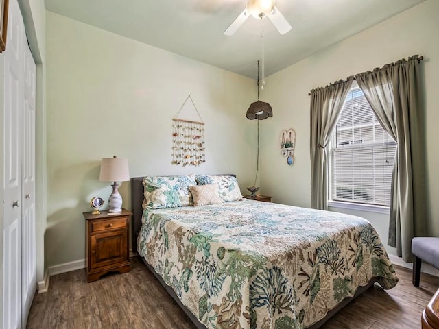 bedroom with dark wood-type flooring, ceiling fan, and a closet