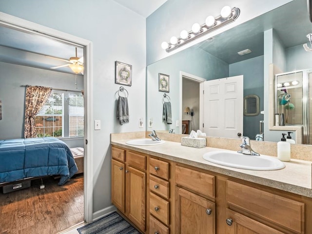 bathroom featuring walk in shower, vanity, hardwood / wood-style flooring, and ceiling fan