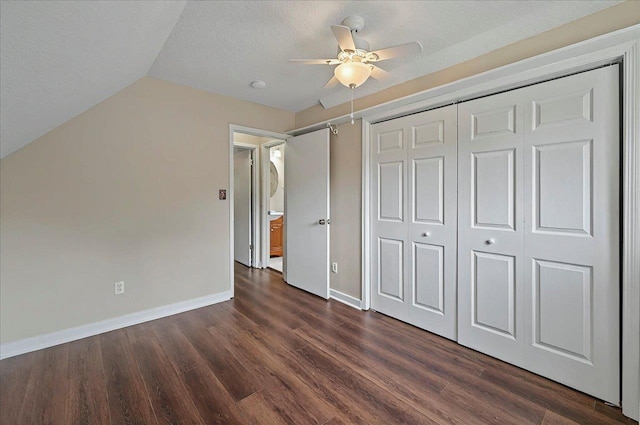 6847 Donerail Trl, Tallahassee, FL 32309 - unfurnished bedroom featuring dark wood-style floors, baseboards, a closet, lofted ceiling, and a textured ceiling