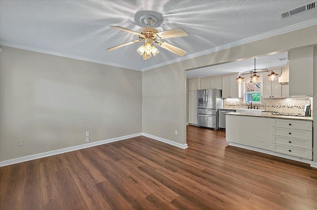 6847 Donerail Trl, Tallahassee, FL 32309 - kitchen featuring appliances with stainless steel finishes, ceiling fan, dark wood-type flooring, backsplash, and crown molding