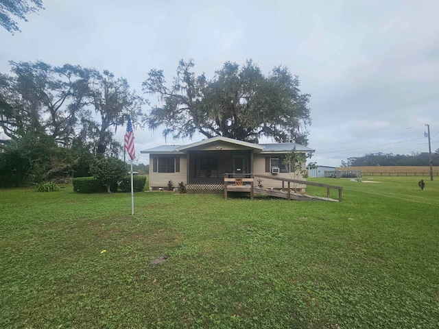 back of property with a lawn and a deck