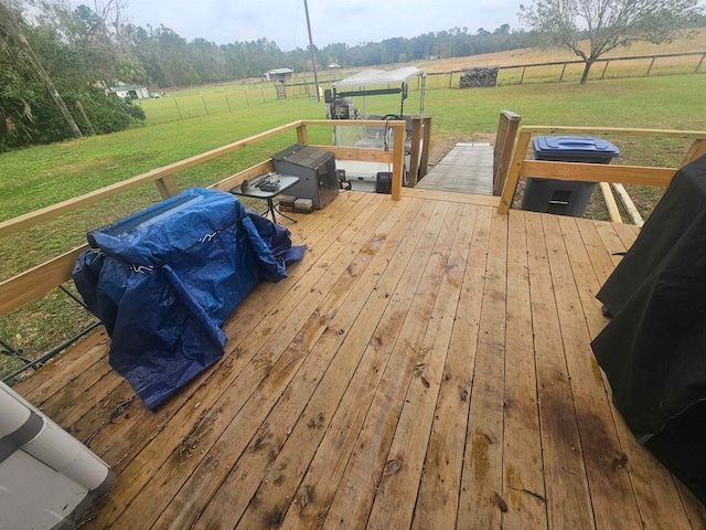 wooden deck featuring a lawn and a rural view