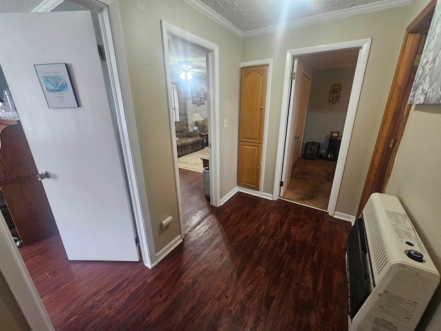 hall featuring dark wood-type flooring, heating unit, a textured ceiling, and crown molding