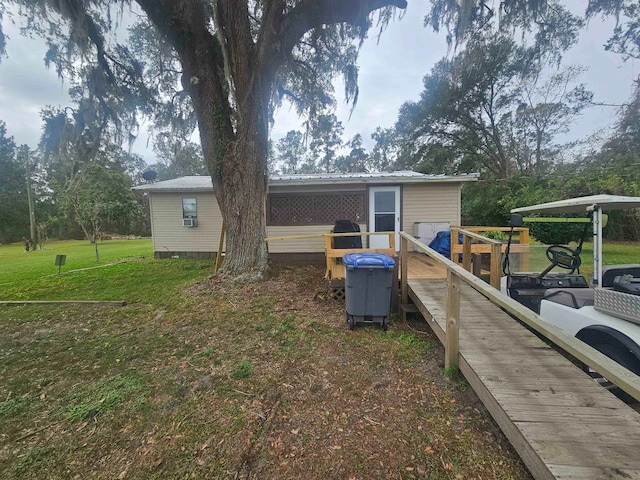 back of property featuring a wooden deck and a yard