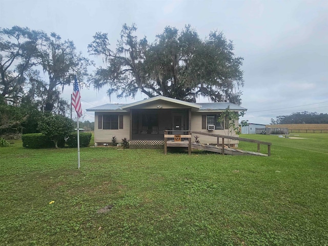 rear view of property featuring a lawn and a deck