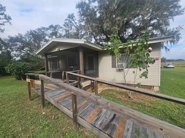 exterior space featuring a sunroom and a yard