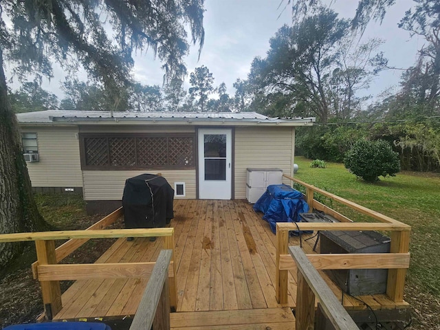 wooden terrace featuring a yard and a grill