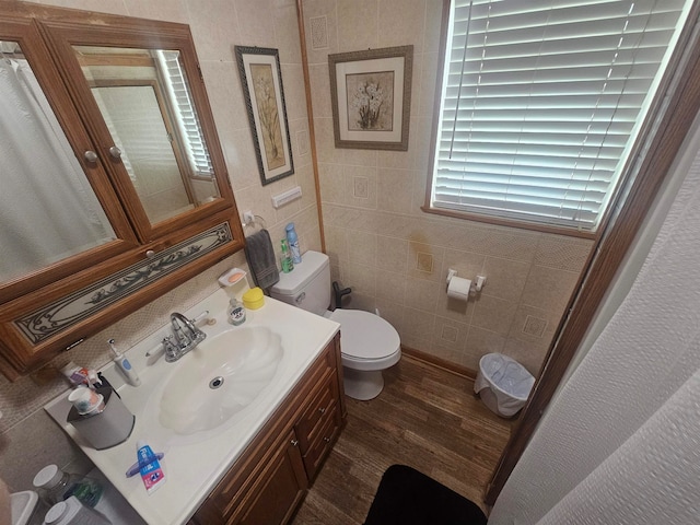 bathroom featuring hardwood / wood-style floors, vanity, toilet, and tile walls