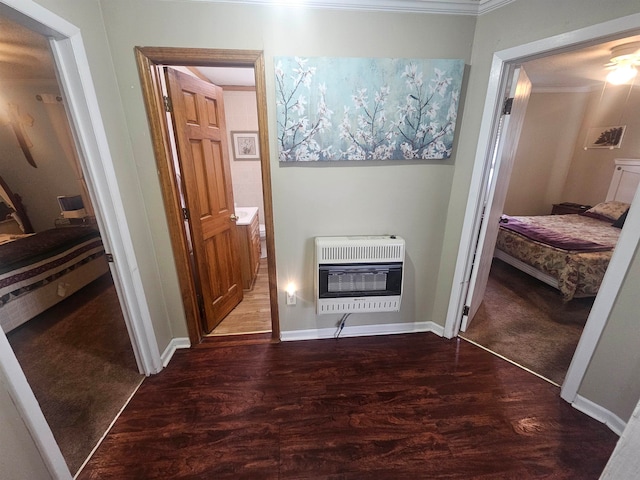 corridor featuring dark hardwood / wood-style flooring, heating unit, and ornamental molding