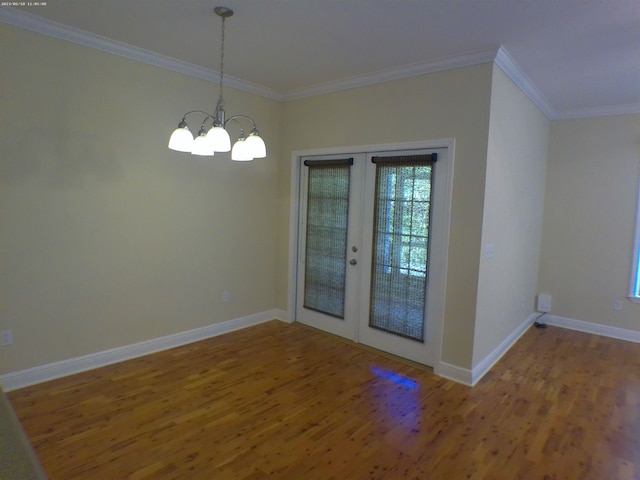 unfurnished dining area with an inviting chandelier, french doors, hardwood / wood-style flooring, and ornamental molding