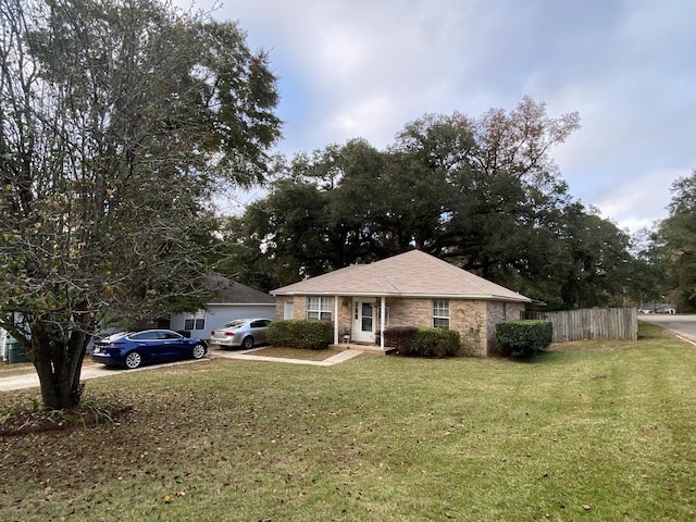 ranch-style home with concrete driveway, a front lawn, fence, and brick siding