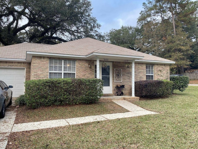 single story home featuring a garage, a front yard, and brick siding