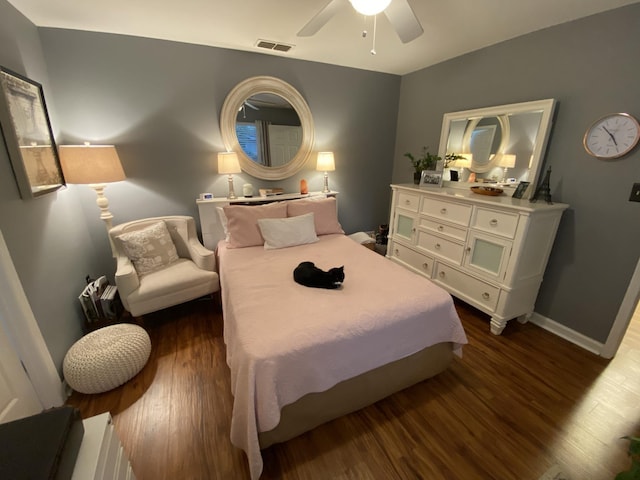 bedroom featuring dark wood-type flooring, visible vents, ceiling fan, and baseboards