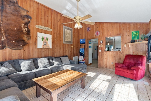 living room with ceiling fan, wooden walls, vaulted ceiling, and tile patterned floors