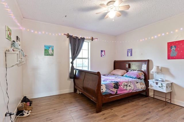 bedroom with a textured ceiling, light wood finished floors, and crown molding