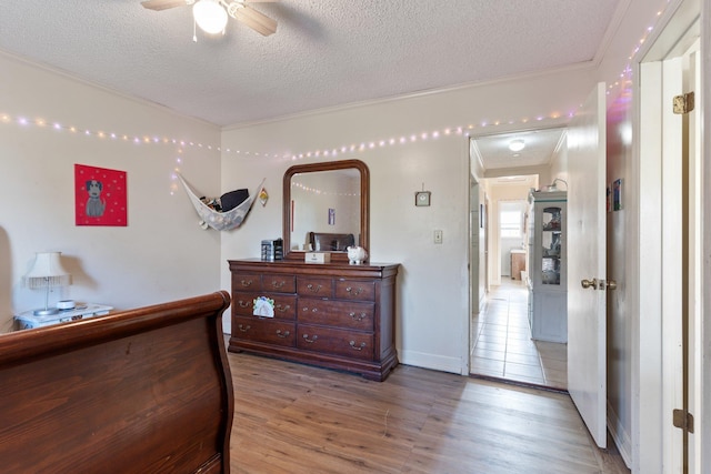 bedroom featuring a textured ceiling, baseboards, and wood finished floors