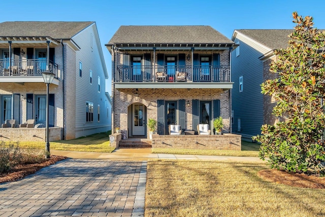 view of front of property with a balcony and a front lawn