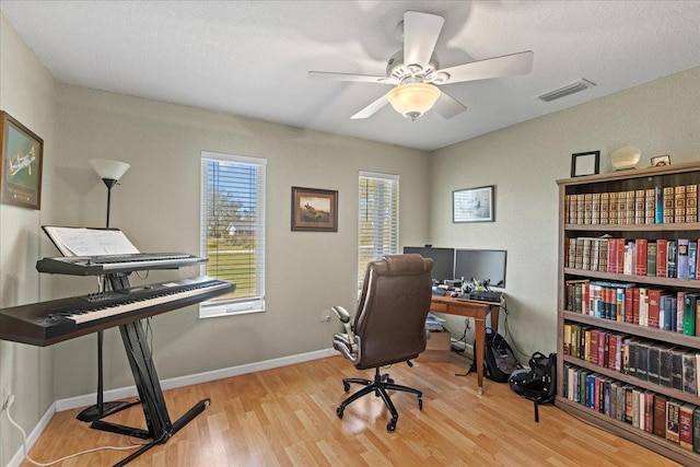 office featuring visible vents, a ceiling fan, baseboards, and wood finished floors