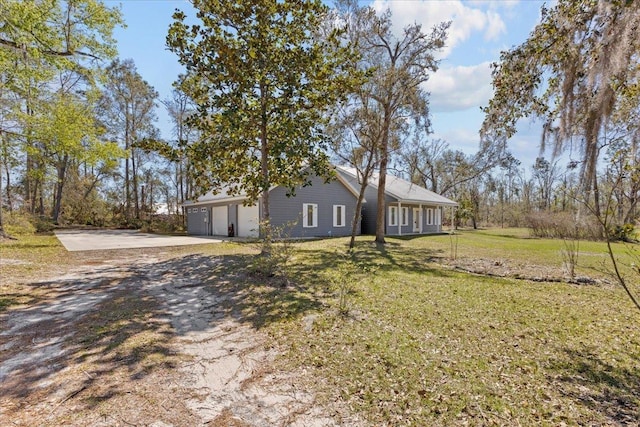 exterior space with driveway, an attached garage, and a front lawn