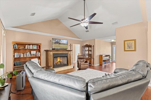 living area featuring visible vents, a lit fireplace, a ceiling fan, and hardwood / wood-style flooring