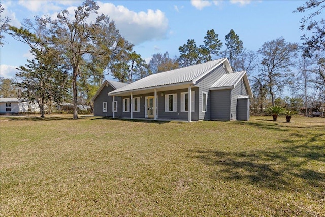 view of home's exterior featuring covered porch, metal roof, and a yard