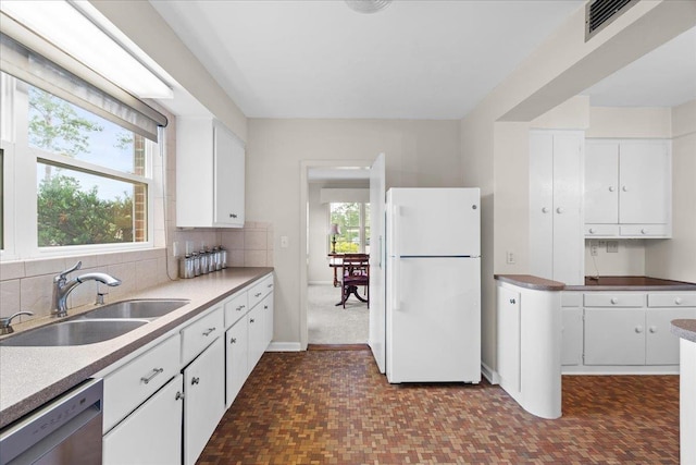 921 Forest Dr, Quincy, FL 32351 - kitchen with freestanding refrigerator, dishwasher, white cabinetry, and backsplash
