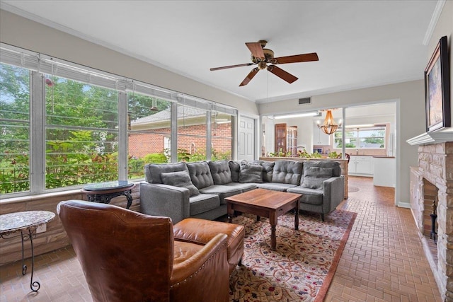 921 Forest Dr, Quincy, FL 32351 - living area with brick patterned floors, a ceiling fan, a chandelier, ornamental molding, and a stone fireplace