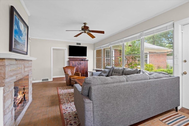 921 Forest Dr, Quincy, FL 32351 - living room with a stone fireplace, brick patterned floors, ceiling fan, plenty of natural light, and crown molding