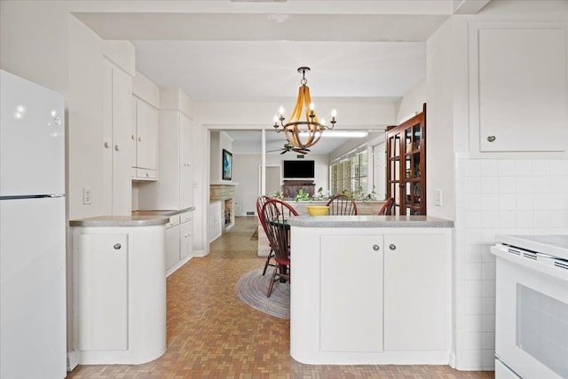 921 Forest Dr, Quincy, FL 32351 - kitchen featuring white appliances, a chandelier, white cabinetry, light countertops, and hanging light fixtures