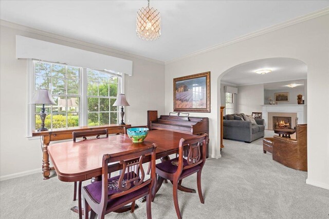 921 Forest Dr, Quincy, FL 32351 - dining room with arched walkways, light colored carpet, ornamental molding, plenty of natural light, and a warm lit fireplace