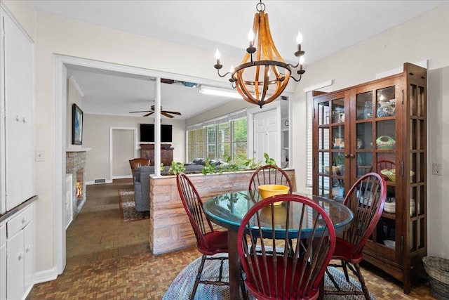 921 Forest Dr, Quincy, FL 32351 - dining area featuring a ceiling fan, a chandelier, and a lit fireplace