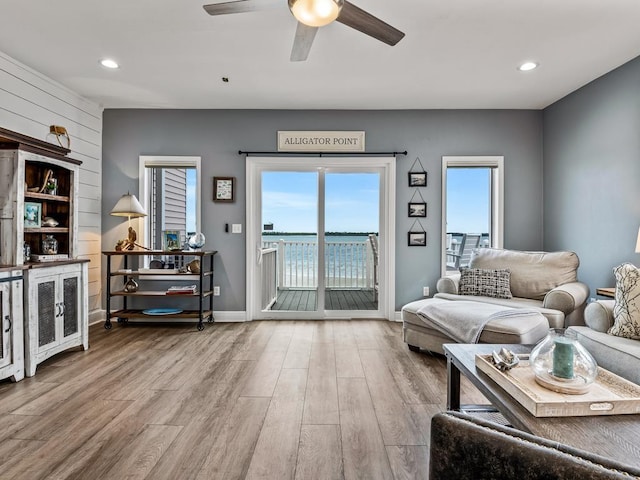 living room featuring ceiling fan, wood finished floors, baseboards, and recessed lighting