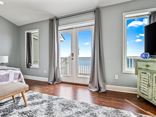 bedroom with access to exterior, wood finished floors, french doors, and baseboards
