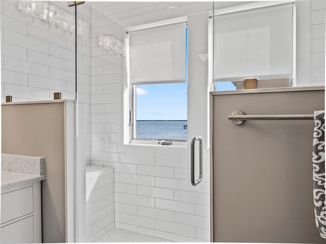 bathroom featuring a stall shower, vanity, and a water view