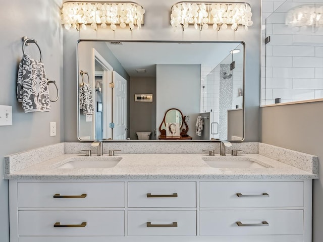 full bath featuring a shower stall, double vanity, and toilet