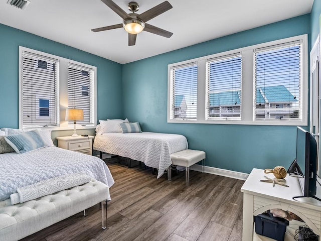 bedroom featuring wood finished floors, baseboards, and a ceiling fan