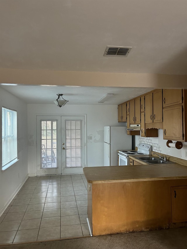 kitchen with french doors, light tile patterned flooring, sink, kitchen peninsula, and white appliances