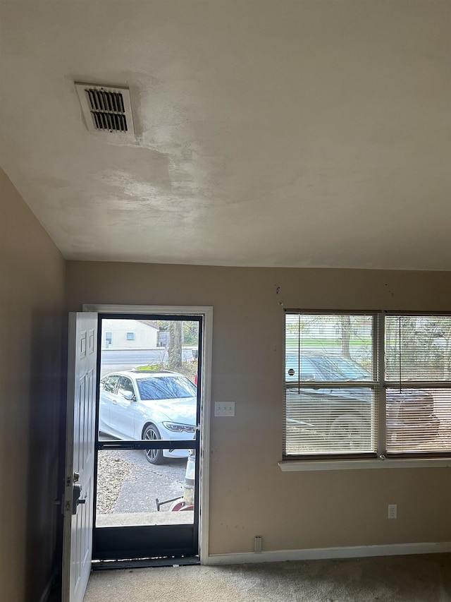 interior space with plenty of natural light and light colored carpet