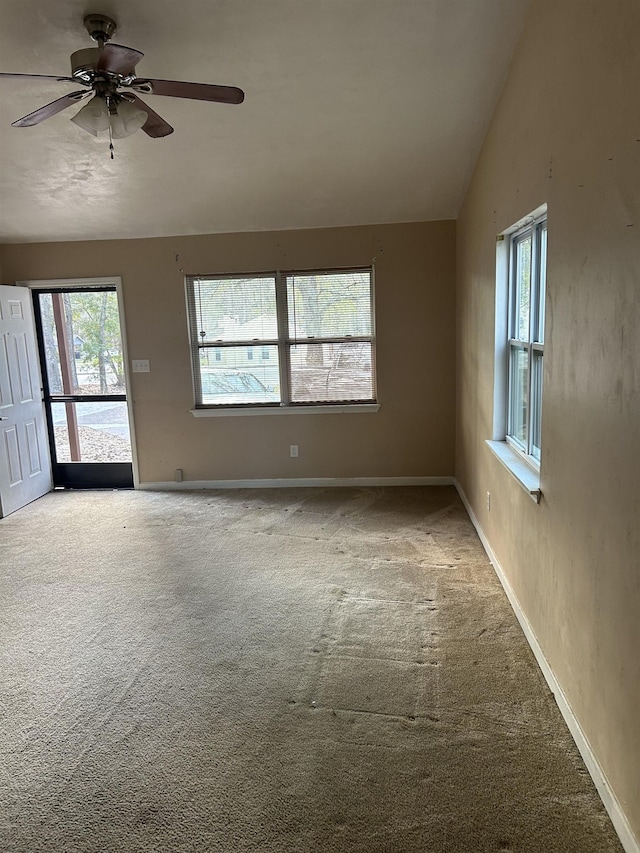 spare room featuring carpet, a wealth of natural light, lofted ceiling, and ceiling fan