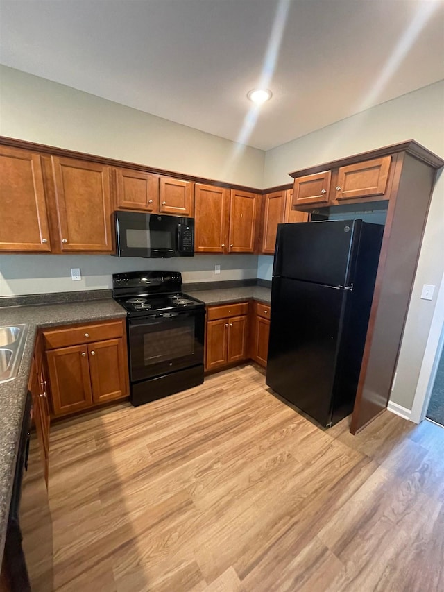 2281 Del Carmel Way, Tallahassee, FL 32303 - kitchen with black appliances, light wood-style flooring, brown cabinetry, and dark countertops