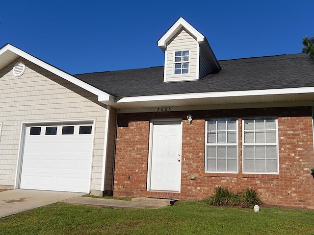 view of front of property featuring a front lawn and a garage