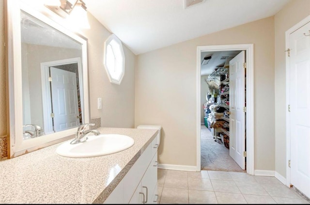 bathroom with vanity, lofted ceiling, and tile patterned floors