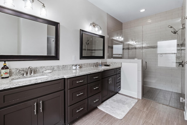 bathroom featuring vanity and a shower with door