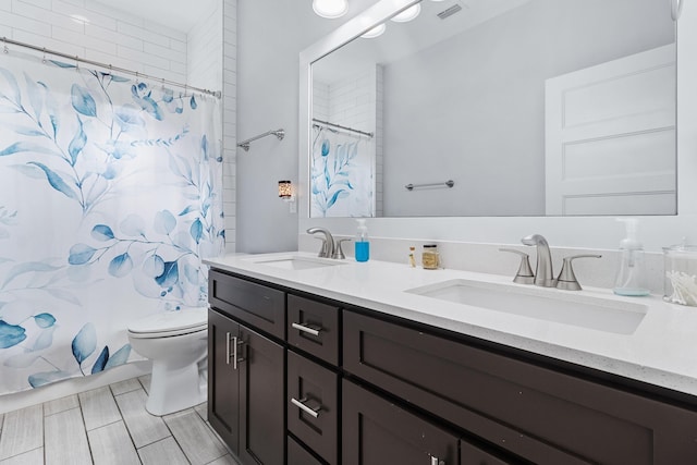 full bathroom featuring vanity, shower / bath combo with shower curtain, and toilet